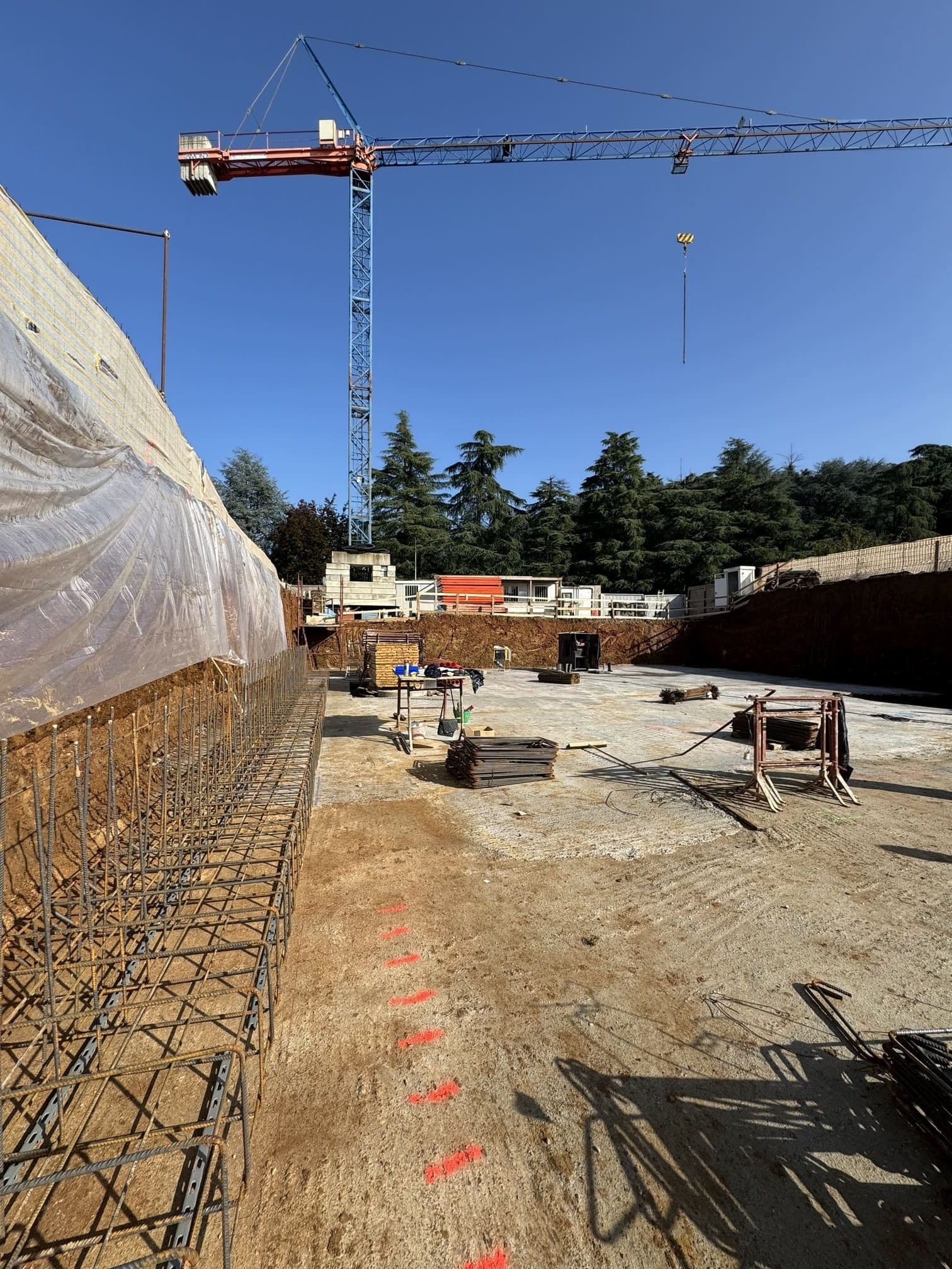 Residenza Superga, cantiere: scavo di fondazione con gru a torre e armature in ferro